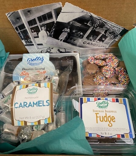 mailer showing Dolle's® postcards, bag of chocolate covered sea salt caramels, bag of non pareils, bag of plain caramels, and container of fudge