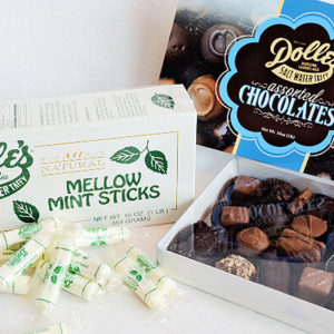 Mellow Mint Sticks stacked in front of their box next to opened box of Assorted Boxed Chocolates