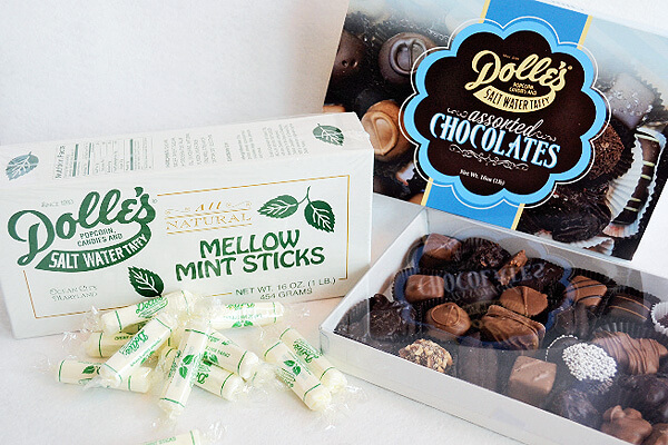 Mellow Mint Sticks stacked in front of their box next to opened box of Assorted Boxed Chocolates