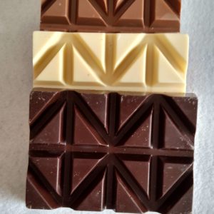 Stack of dark, white, and milk bars of chocolate