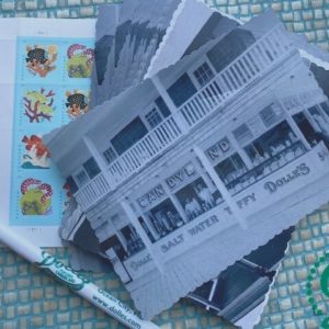 stack of Dolle's® historic photo postcards with pen and stamps