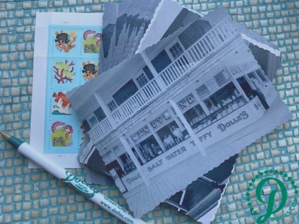 stack of Dolle's® historic photo postcards with pen and stamps